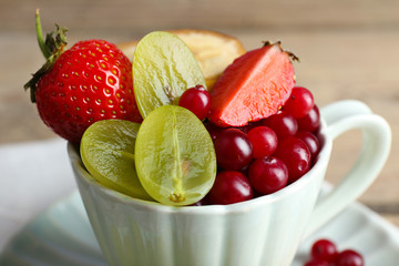 Cup of dessert with fresh fruits on wooden table, closeup