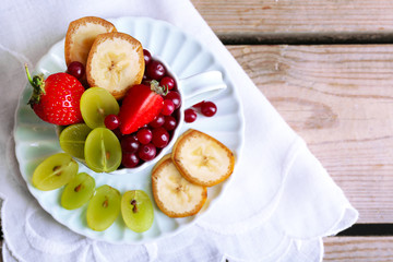Cup of dessert with fresh fruits on wooden table, closeup
