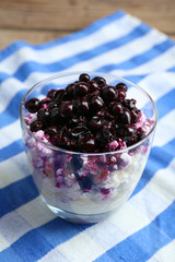 Cottage cheese with black canned currant on striped napkin, closeup