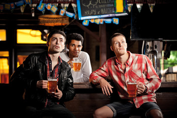 Watching TV in bar. men drinking beer sitting  bar