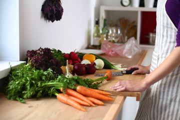 Young woman cutting vegetables in the kitchen