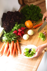 Young woman cutting vegetables in the kitchen