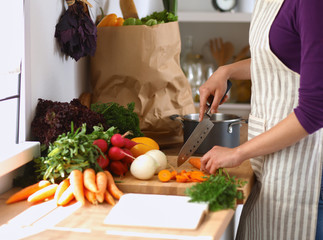 Young woman cutting vegetables in the kitchen