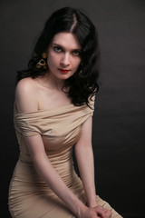 Portrait of beautiful young woman sitting over black background