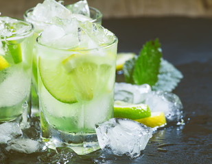 Lemon-lime green drink with crushed ice on a dark background, se