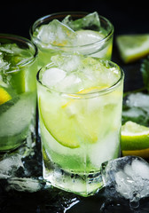 Lemon-lime green drink with crushed ice on a dark background, se