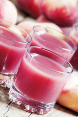 Pink peach juice with pulp, selective focus