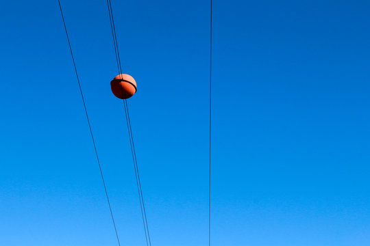 Red sphere on a power line, a caution symbol for low flying planes