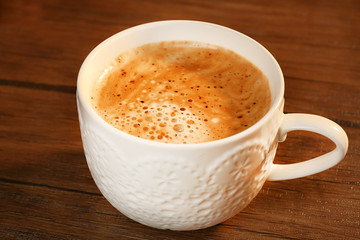 Cup of fresh coffee on wooden table, closeup