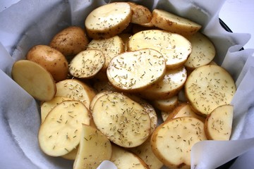 Raw and sliced potatoes with rosemary