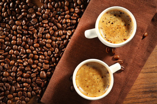 Two cups of fresh coffee with beans on table, top view © Africa Studio