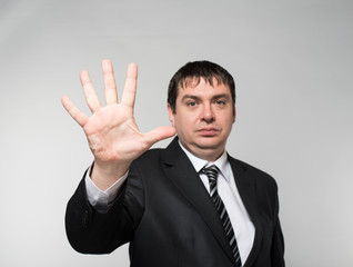 Happy businessman showing five fingers on a gray background
