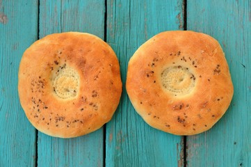 Two round chapatis with sesam seeds on blue wooden table
