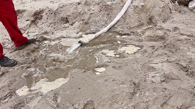 Sand absorbs water. After backfilling the trench sand is watering with water.

