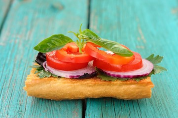 Bruschetta with red onion, pepper, tomatoes and basil on blue wo