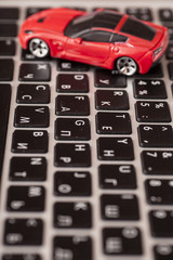 Toy car over laptop keyboard