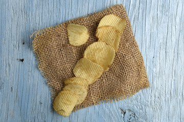 Fototapeta na wymiar Potato chips on old wooden table