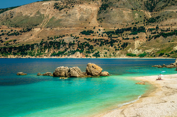 Vouti beach, Kefalonia island, Greece. People relaxing at the beach. The beach is surrounded by flowers.