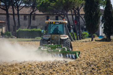 Tractor at work after grain harvest, Tuscany
