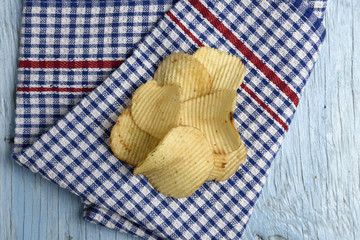 Potato chips on old wooden table