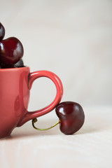 Cherry in a cup on the wooden table