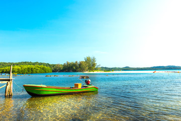 Fototapeta premium Green canoe on shallow water at the beach