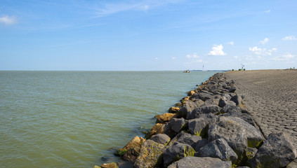 Dike along the shore of a lake in summer