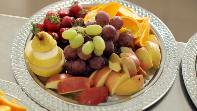 Sliced pear, orange, apple, strawberries and grapes lying on a