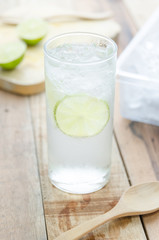 Cool lemon water on wood background