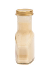Glass bottle of white sauce. Isolated on white background