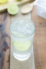 Cool lemon water on wood background