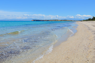 Panoramic view of a long white sand beach beside the turquoise s