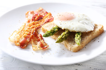 Dish of asparagus and egg in plate on table, closeup