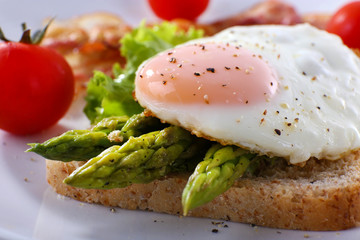 Dish of asparagus and egg in plate on table, closeup