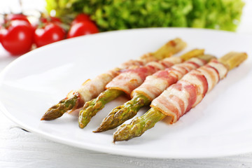 Dish of asparagus and bacon in plate, closeup