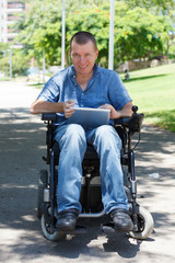 Happy disabled man using tablet at the park