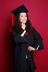 Studio portrait picture from a young graduation woman on red background