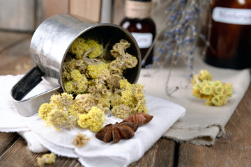 Dried herbs and bottles with tinctures on table close up