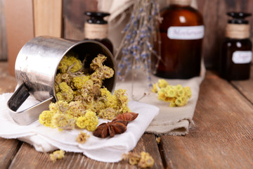Dried herbs and bottles with tinctures on table close up