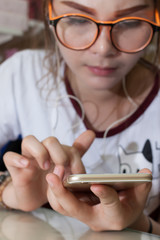 Teen girl listening to the music from a smart phone lying
