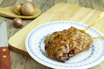 pork stick grilled in a plate on wooden