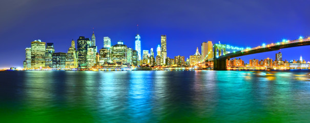 Obraz na płótnie Canvas Panorama of Manhattan skyline and Brooklyn Bridge at night.