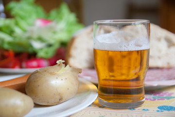 The glass of beer with boiled potatoes