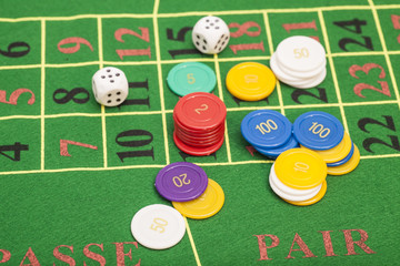 casino chips and dices stacking on a green felt