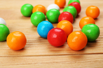Colorful candies on wooden table, closeup