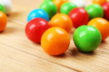 Colorful candies on wooden table, closeup