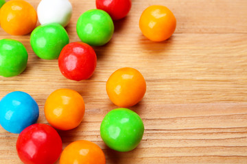 Colorful candies on wooden table, closeup
