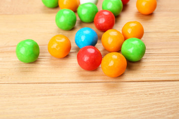 Colorful candies on wooden table, closeup