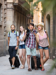 Couples with baggage walking the city.