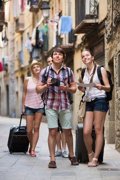 Group of merry tourists with camera and map